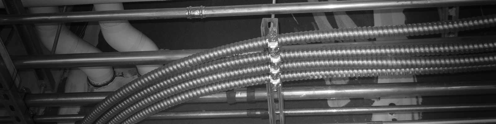 Feeder MC armored electrical cable run next to traditional conduit